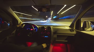 Vehicle with EPS power steering driving down a highway at night